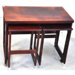 A nest of three 1960s rosewood tables, largest on wheels, width 74cm.