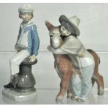 A Lladro figurine of a young Japanese boy with a donkey and a further figure of a young boy holding