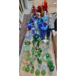 A large quantity of decorative glass, mainly red/orange, green and blue including vases, baskets,