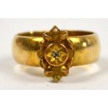 A 9ct gold wedding band later set with gold floral motif, possibly from a brooch, approx 4.2g.