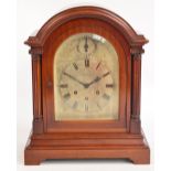 An Edwardian mahogany cased domed mantel clock with silvered dial set with Roman numerals and