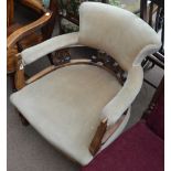 An Edwardian tub chair with padded arms and seats raised on square section cabriole front legs.