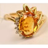 A contemporary 14ct yellow gold ring set with oval cut citrine beside six diamonds, ring size L.