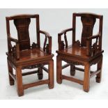 A pair of decorative early 20th century Chinese elbow chairs with shaped central splat decorated