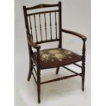 An Edwardian mahogany and inlaid elbow chair with padded seat and ring turned front legs.