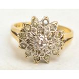 An 18ct yellow gold floral cluster ring, the central brilliant cut diamond of approx 0.