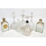 Seven glass decanters including an example with silver collar, a pair of gilt heightened examples,