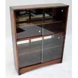 A Herbert Gibbs bookcase with sliding glass doors.