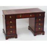 A reproduction mahogany nine drawer pedestal desk raised on bracket feet.