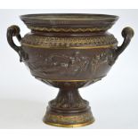 A bronze twin handled urn decorated with classical recumbent scantily clad female figures,