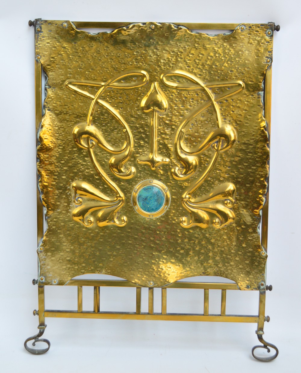 An early 20th century brass fire screen with Art Nouveau decoration of stylised foliage centred on a