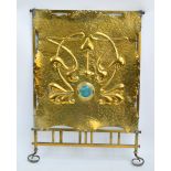 An early 20th century brass fire screen with Art Nouveau decoration of stylised foliage centred on a