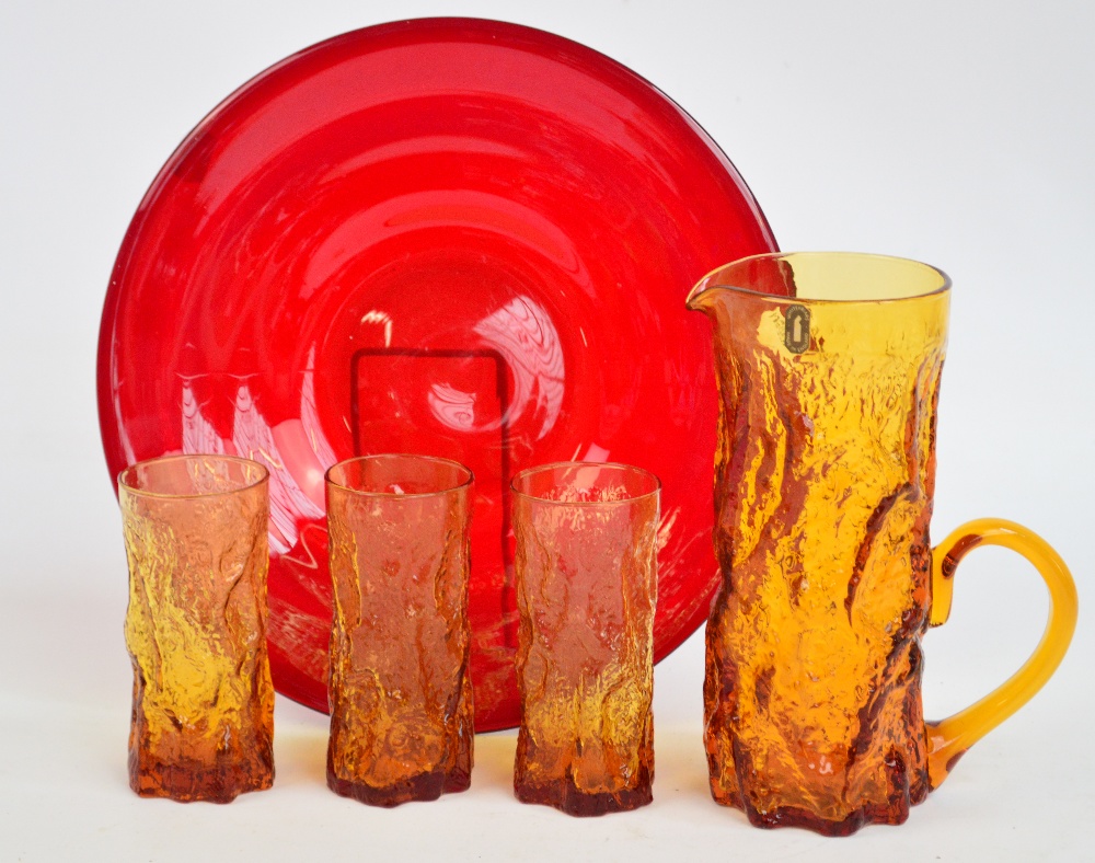 A Whitefriars orange bark tall jug and three glasses, and a red circular plate (5).