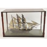 An early 20th century model of a three masted galleon in glazed case with turned wooden corner