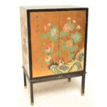 An Oriental cabinet decorated with honeysuckle and other blossoms and rocks on a gold ground,