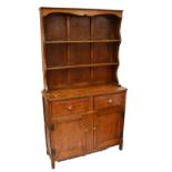 An early 20th century oak dresser, the plate rack above two drawers and pair of panel doors,