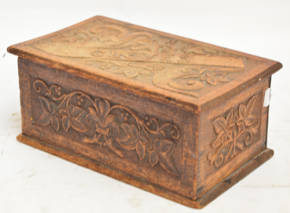 An Edwardian carved oak glove box with hinged lid, width 36cm.