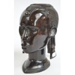 A decorative African carved ebony figure of a woman's head with long earrings, height 25cm.