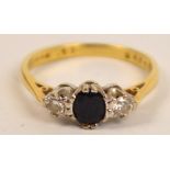 An 18ct yellow gold three stone ring with sapphire flanked by two diamonds in claw setting,