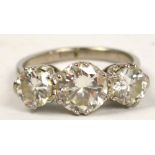 An unmarked 18ct white gold three stone diamond ring,