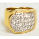 A modern pave set diamond ring with twenty-three small diamonds in a white metal shaped setting, set