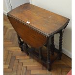 A mid 20th century oak D-end gateleg table raised on barleytwist supports,