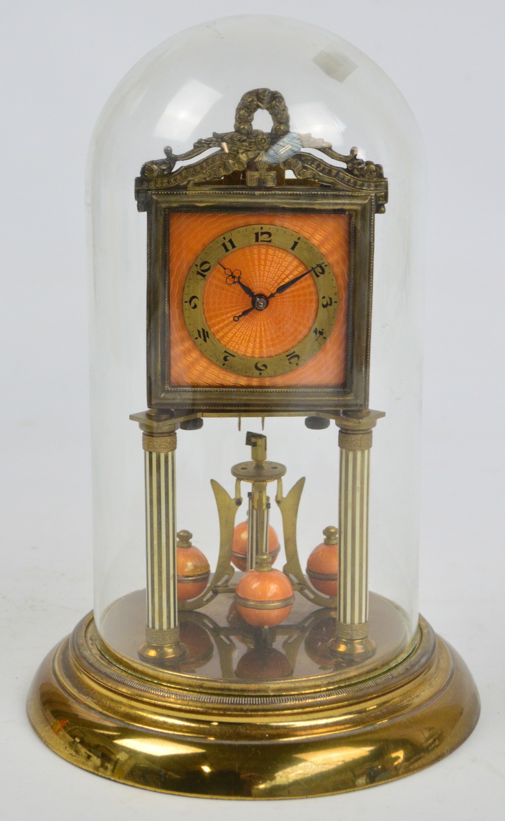 A 1930s anniversary clock with orange enamel square dial,