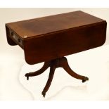 A 19th century mahogany pedestal Pembroke table with end drawer on turned column and four carved