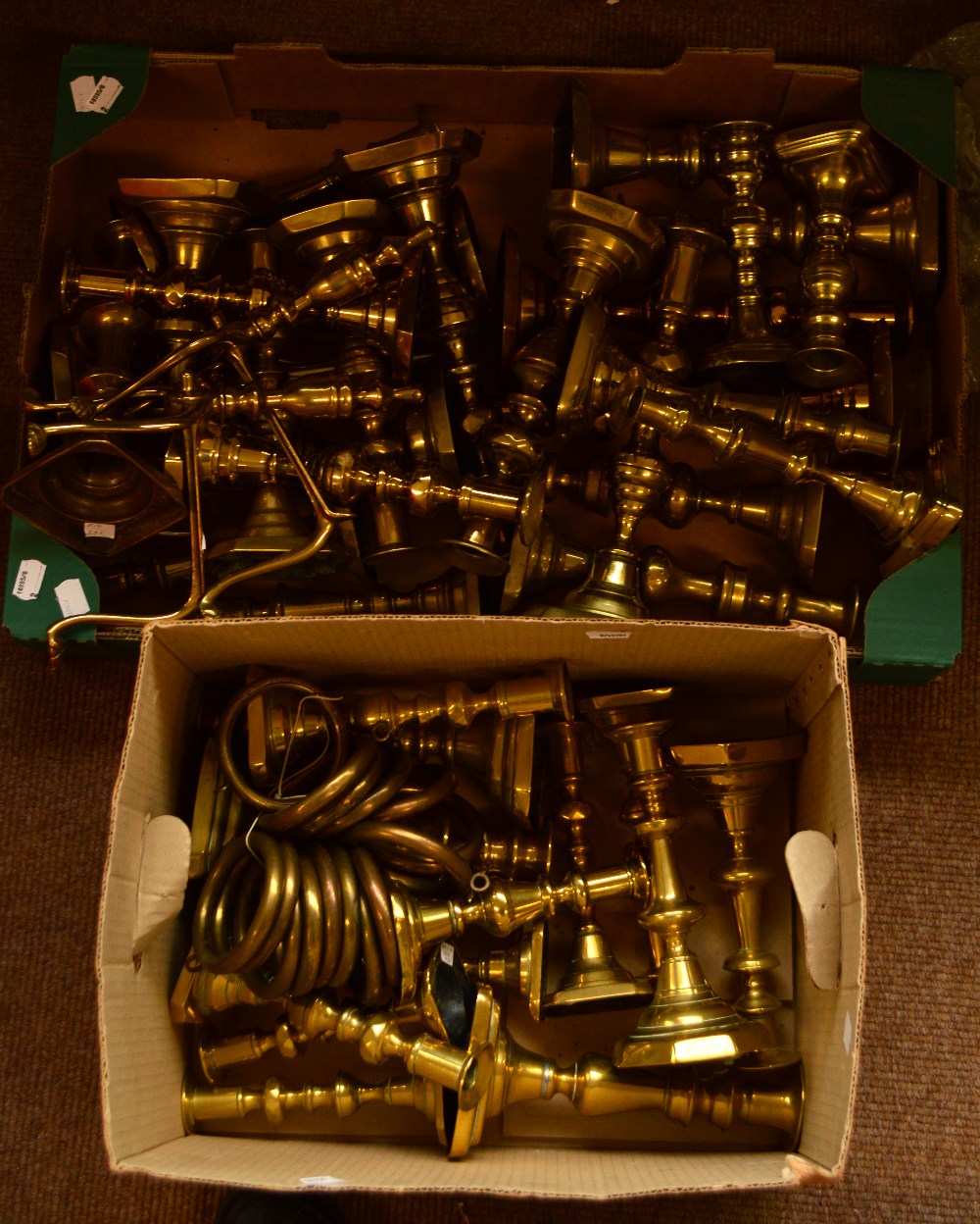 A large quantity of predominantly 19th century brass candlesticks,