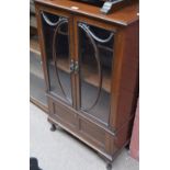 A mahogany two door glazed display cabinet with single base drawer on squat cabriole legs to pad