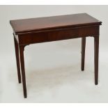 A mahogany tea table with rectangular foldover top raised on square gateleg supports.