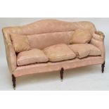 An Edwardian upholstered settee with shaped back, loose cushions,