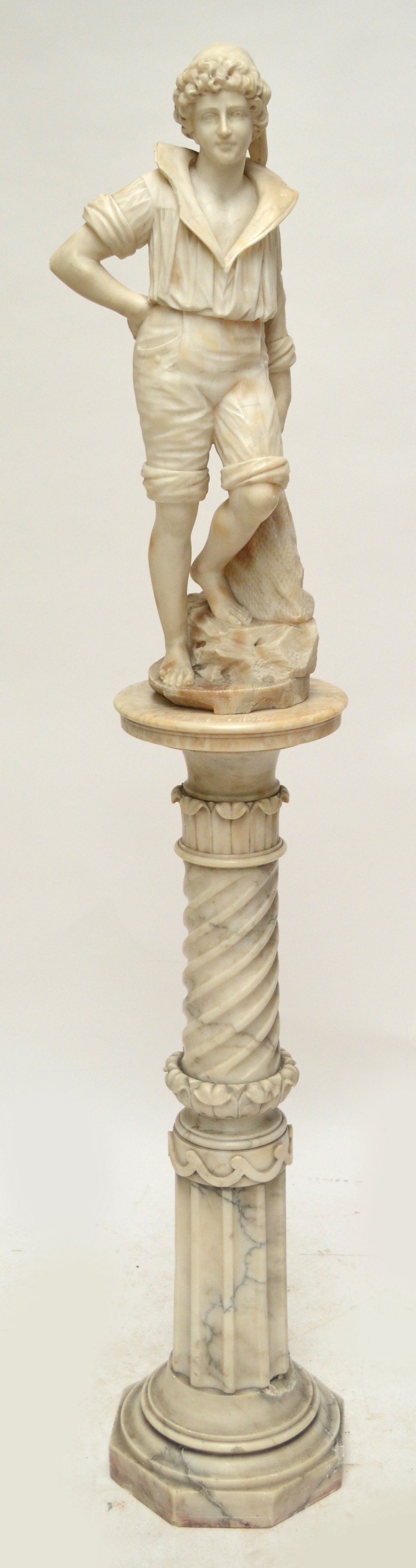 A late 19th/early 20th century carrara alabaster figure of a young fisherman modelled with a net