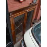 A Victorian mahogany bookcase topped with twin leaded glazed doors.