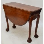 A 20th century mahogany dropleaf dining table with gadrooned rim above cabriole legs on ball and