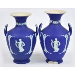 A pair of late 19th/early 20th century Wedgwood blue jasperware twin handled vases decorated in