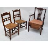 A 19th century mahogany elbow chair with pierced splat back, and two rush seated side chairs.