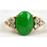 An 18ct yellow gold ring set with oval green jadeite stone flanked by six brilliant cut diamonds,