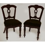 A set of four Victorian walnut dining chairs raised on turned fluted front legs.