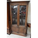 An early 20th century oak bookcase with pair of leaded glazed doors above pair of panel doors.