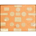 A collection of twenty Chinese mother of pearl gaming counters stuck to a section of fabric and