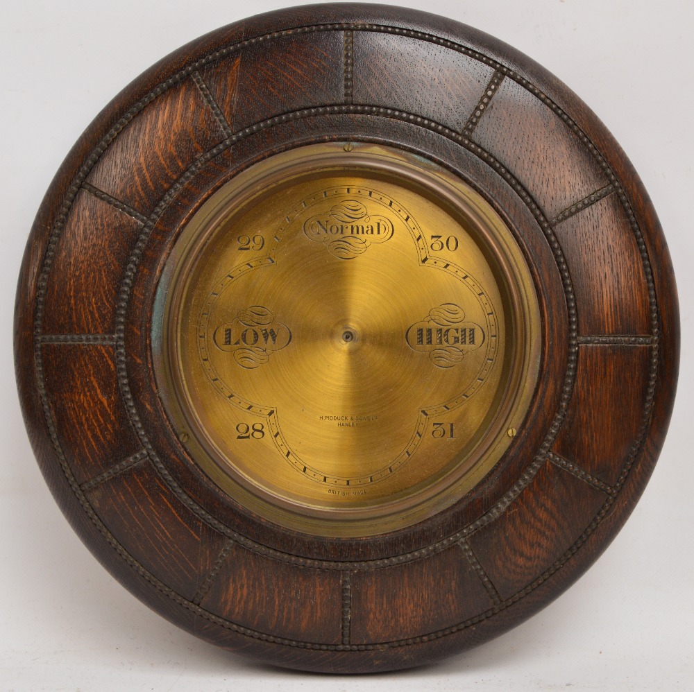 An early 20th century oak circular barometer including "H.