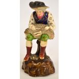 A mid 19th century Lloyd of Fenton figure of a seated man shearing a sheep, c.1840, height 17cm.