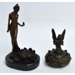 A bronze figure of a woman standing in contrapposto standing on a leaf next to a blossoming lotus