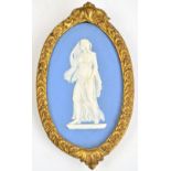 An early 19th century blue and white Wedgwood jasperware plaque of a classical lady in diaphanous