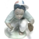 A Lladro figure no.5827, a crouching child playing baseball, height 13.5cm.