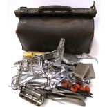 An early 20th century Gladstone bag containing a quantity of various medical instruments.