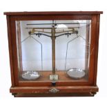 A cased set of Nivac chemical balance scales in glazed mahogany case, height 39.5cm.