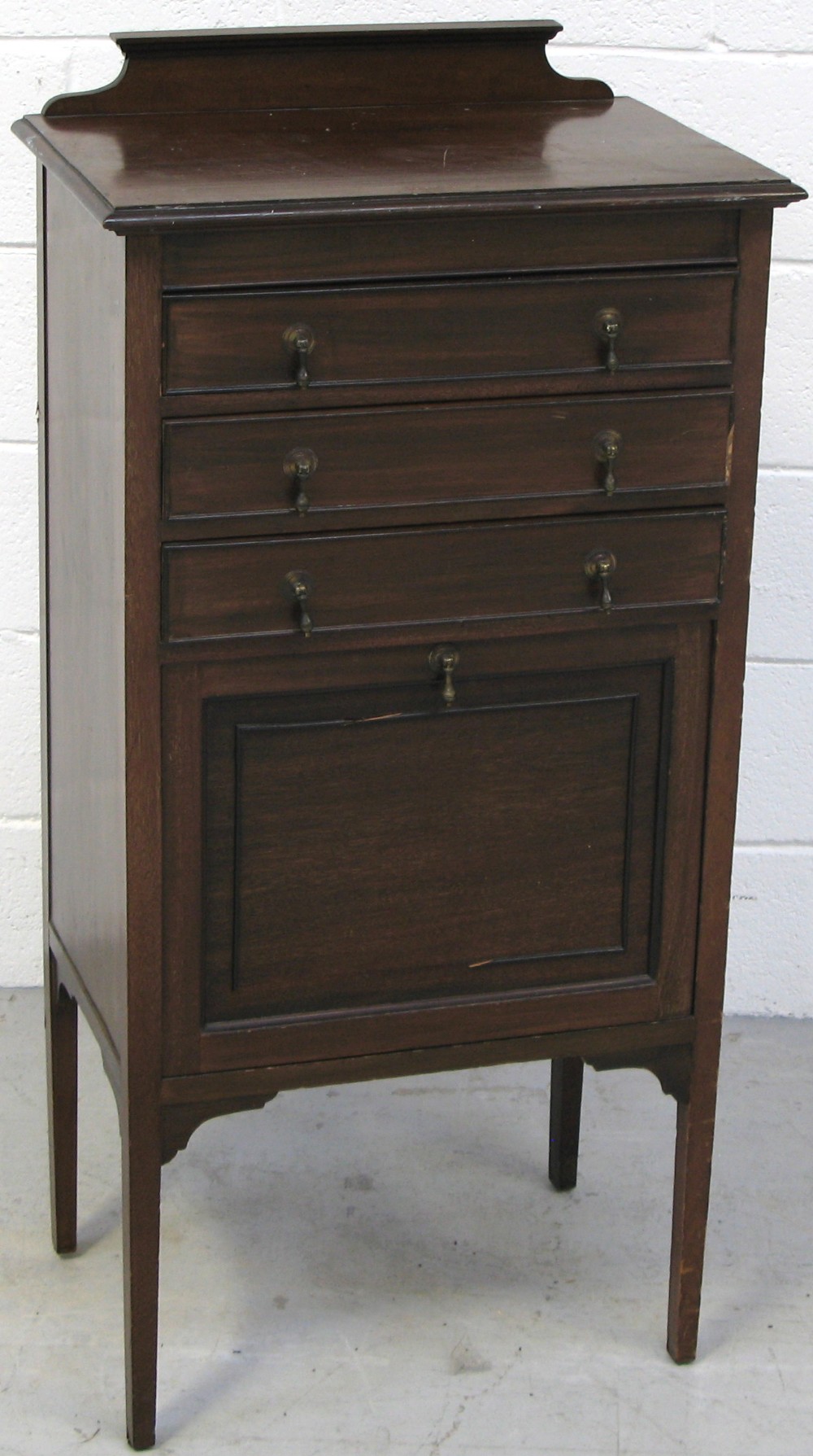 An Edwardian mahogany music cabinet, three upper drawers above a lower fall front hinged cabinet,