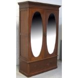 An Edwardian mahogany and inlaid two door mirrored wardrobe raised on a plinth base, width 122cm.